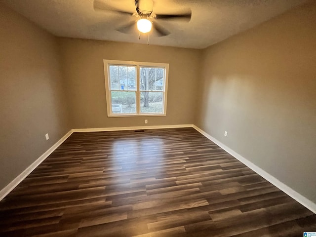 spare room with ceiling fan and dark wood-type flooring