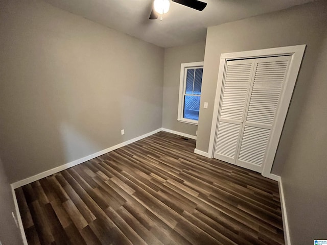 unfurnished bedroom featuring ceiling fan, dark hardwood / wood-style floors, and a closet