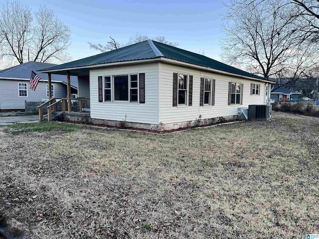 view of side of property featuring a yard and central AC unit