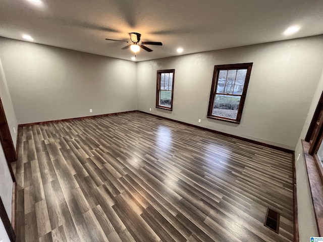 unfurnished room with ceiling fan and dark wood-type flooring