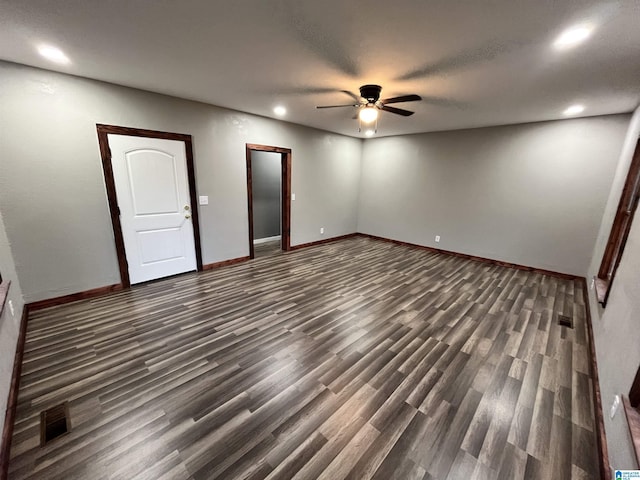 spare room with dark hardwood / wood-style flooring and ceiling fan