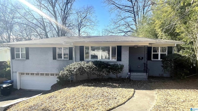 view of front of house with driveway, brick siding, and an attached garage