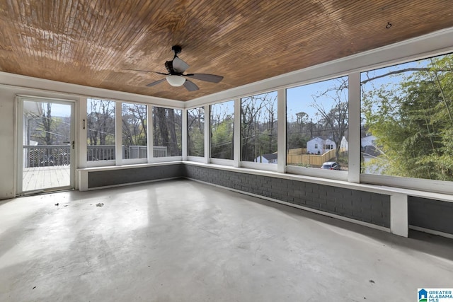 unfurnished sunroom featuring ceiling fan, a wealth of natural light, and wood ceiling