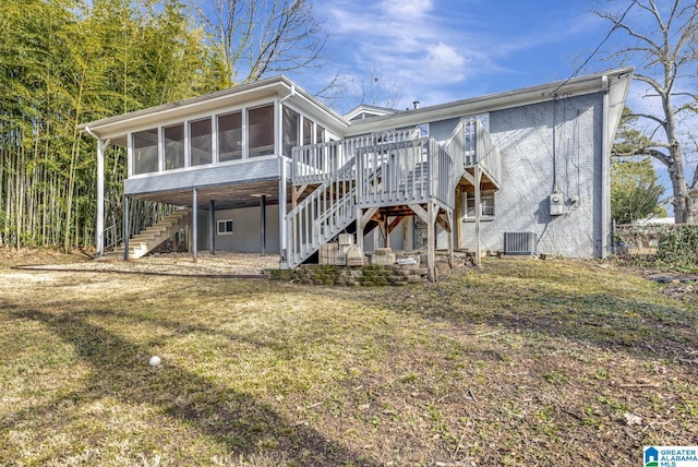 rear view of property with central AC unit, a yard, and a sunroom