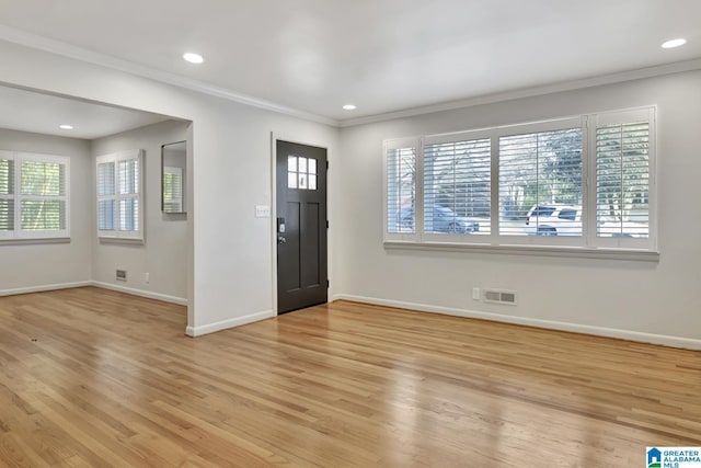 entryway featuring ornamental molding, a healthy amount of sunlight, and light hardwood / wood-style flooring