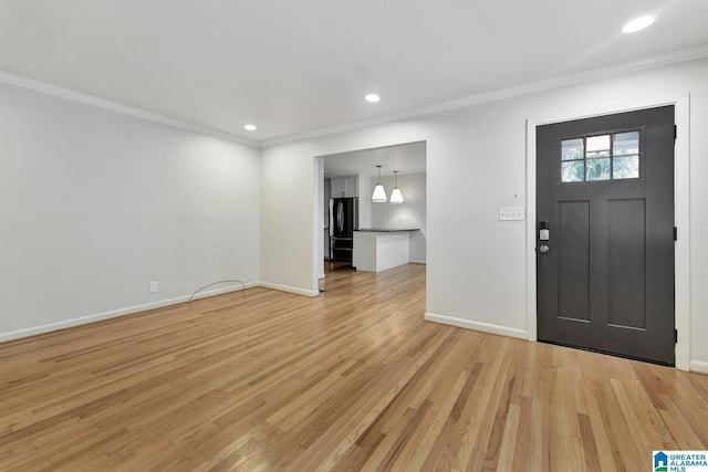 foyer with light hardwood / wood-style floors and ornamental molding