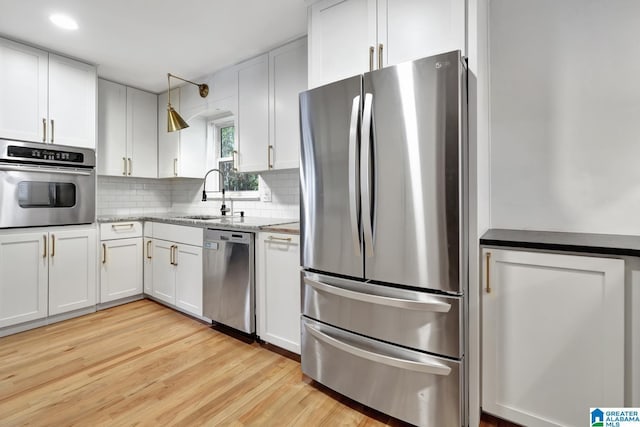 kitchen featuring sink, stainless steel appliances, and white cabinetry