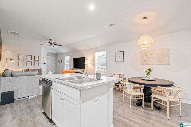 kitchen with dishwasher, a center island with sink, sink, hanging light fixtures, and white cabinetry