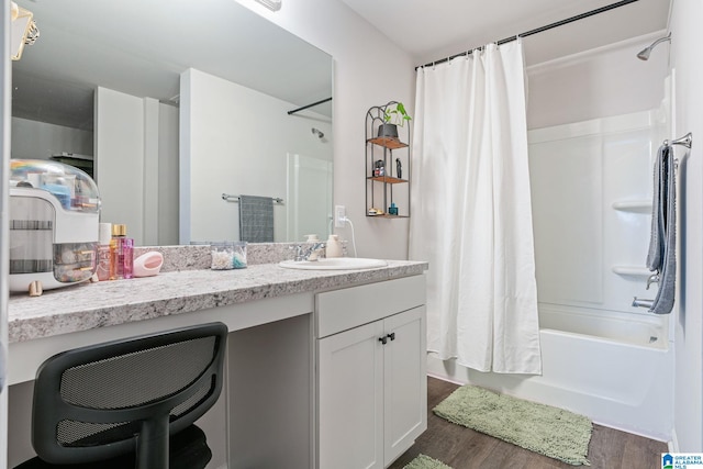 bathroom with hardwood / wood-style floors, shower / bath combination with curtain, and vanity