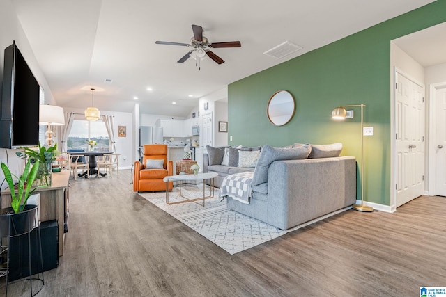 living room featuring light wood-type flooring and ceiling fan