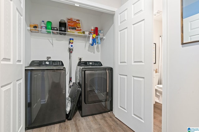 laundry room featuring washer and dryer and light hardwood / wood-style flooring