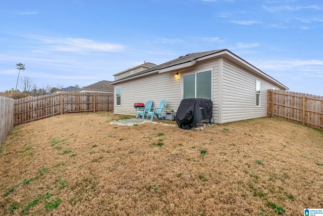 back of property with a lawn and a patio area