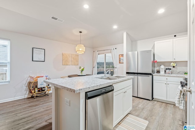 kitchen featuring appliances with stainless steel finishes, light wood-type flooring, a kitchen island with sink, pendant lighting, and white cabinets