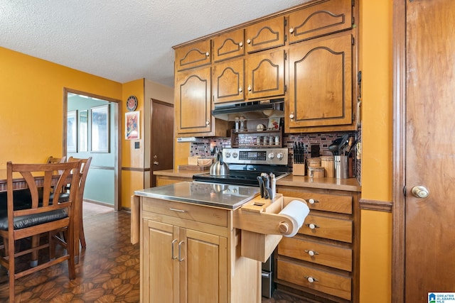 kitchen with stainless steel electric range, stainless steel counters, a textured ceiling, and tasteful backsplash