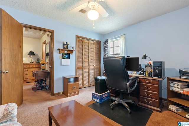 carpeted office featuring ceiling fan and a textured ceiling