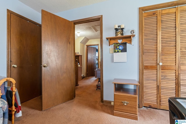 hallway featuring a textured ceiling and light colored carpet