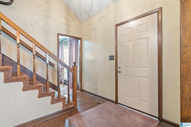 foyer featuring dark parquet flooring and vaulted ceiling