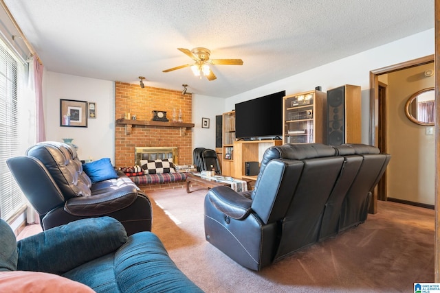 carpeted living room with ceiling fan, a textured ceiling, and a brick fireplace