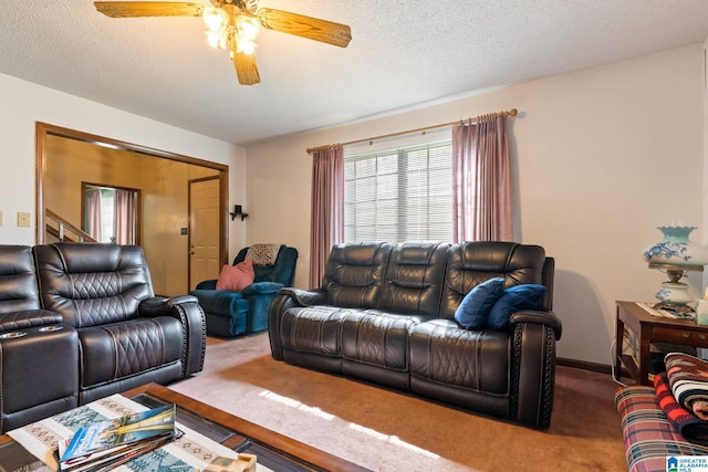 carpeted living room with ceiling fan and a textured ceiling