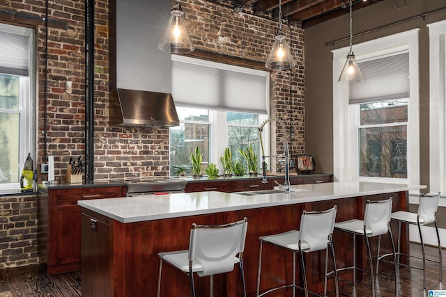 bar featuring decorative light fixtures, brick wall, high end range, and dark hardwood / wood-style flooring