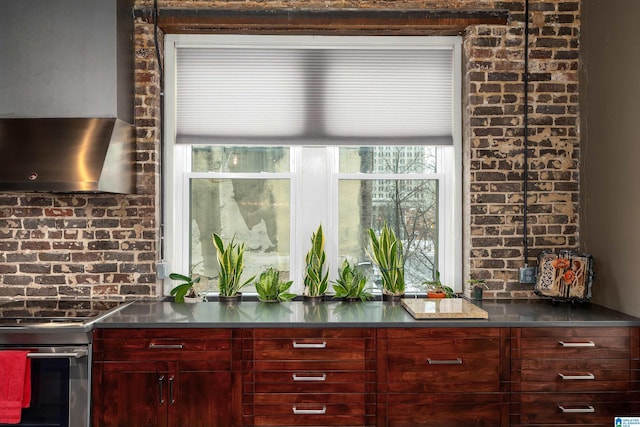 bar featuring brick wall, wall chimney range hood, and stainless steel range with electric stovetop