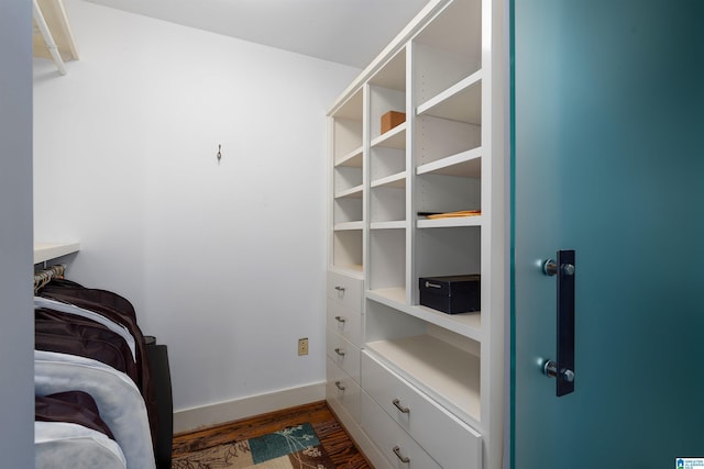 walk in closet with dark hardwood / wood-style flooring