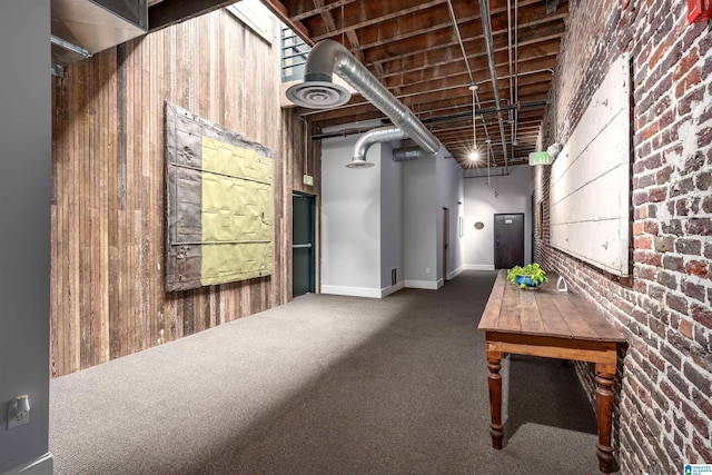 basement with carpet flooring and wood walls