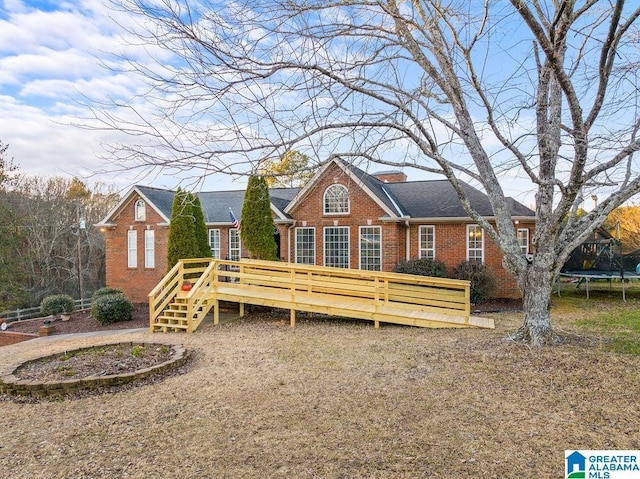 view of front of property with a trampoline and a wooden deck