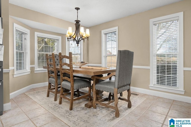 tiled dining room with a healthy amount of sunlight and a chandelier