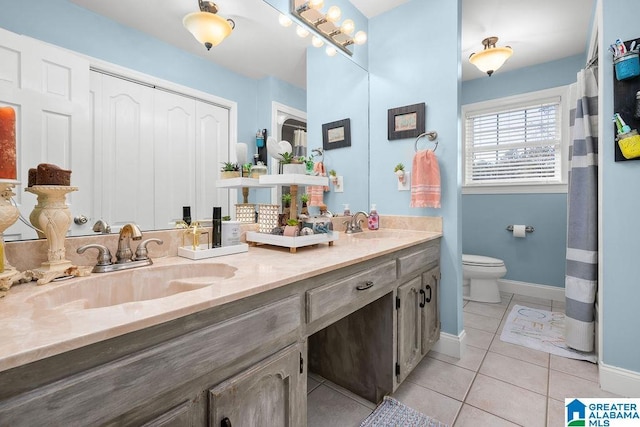 bathroom with tile patterned flooring, vanity, and toilet