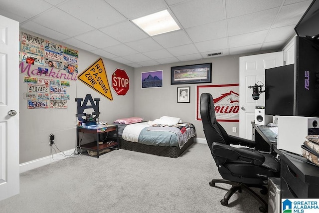 bedroom with carpet flooring and a drop ceiling