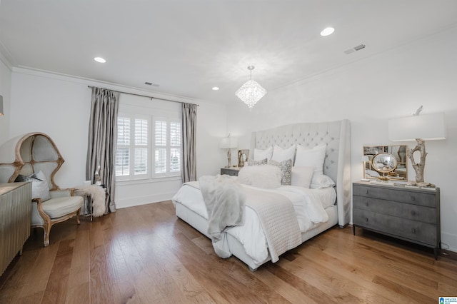 bedroom featuring a notable chandelier, hardwood / wood-style flooring, radiator heating unit, and crown molding