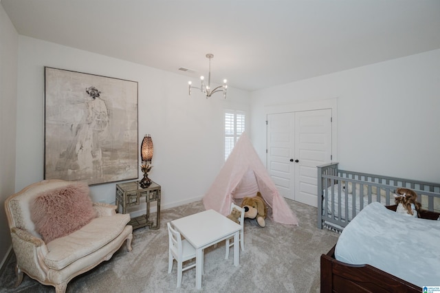 bedroom featuring light colored carpet, a closet, and a chandelier