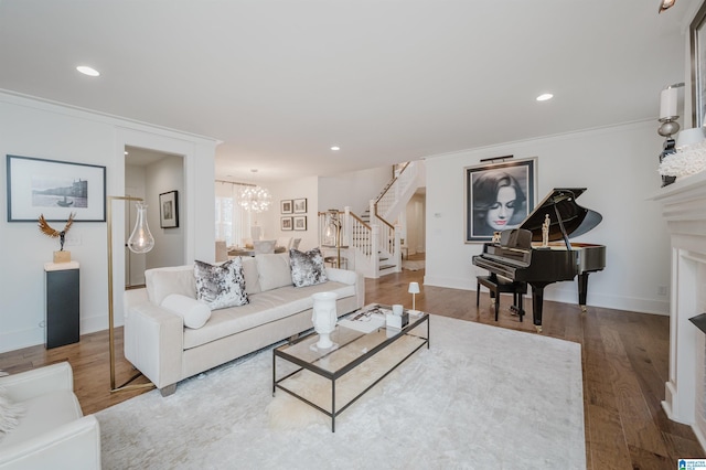 living room with hardwood / wood-style flooring, a chandelier, and crown molding