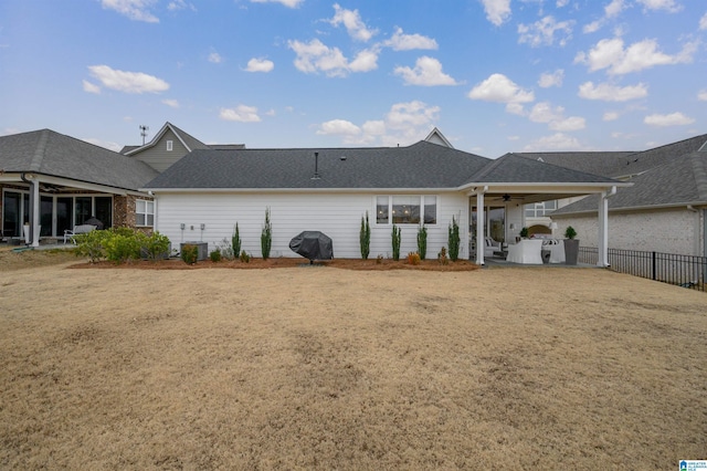 rear view of house with ceiling fan, cooling unit, a lawn, and area for grilling