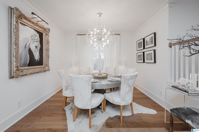 dining room featuring hardwood / wood-style flooring, a notable chandelier, and ornamental molding