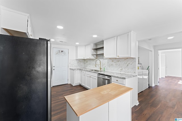 kitchen featuring backsplash, stainless steel appliances, sink, washer and dryer, and white cabinets