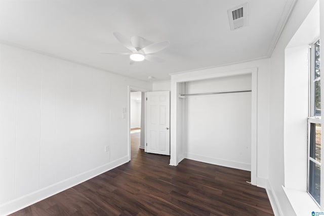 unfurnished bedroom with a closet, ceiling fan, dark hardwood / wood-style flooring, and ornamental molding