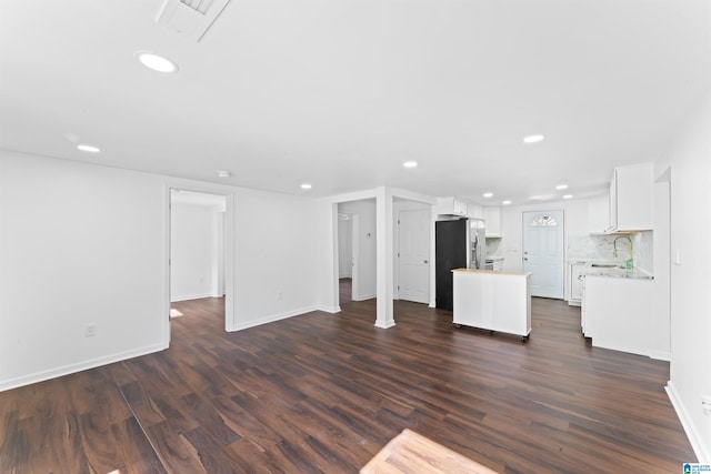 unfurnished living room with sink and dark wood-type flooring