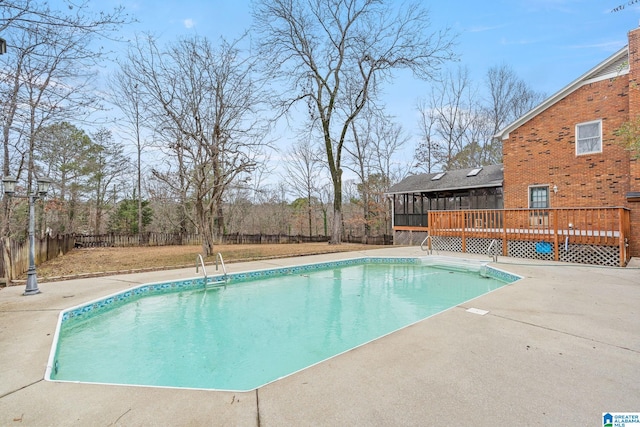 view of pool with a patio, a deck, and a sunroom