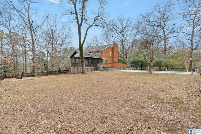 view of yard with a sunroom and a swimming pool side deck