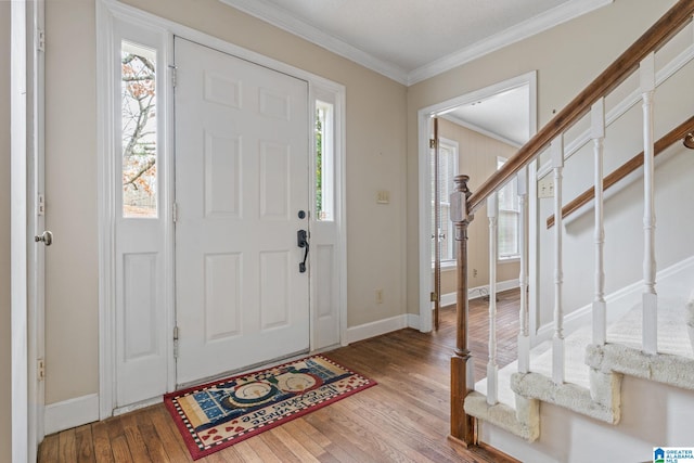 foyer with light hardwood / wood-style floors, crown molding, and a wealth of natural light