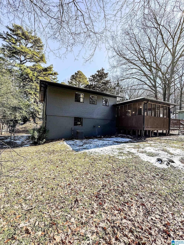 back of house with a sunroom, a yard, and central air condition unit