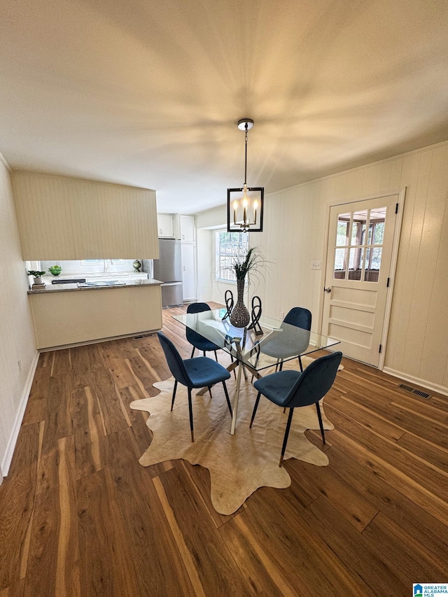 dining room with dark hardwood / wood-style flooring, a wealth of natural light, and a chandelier