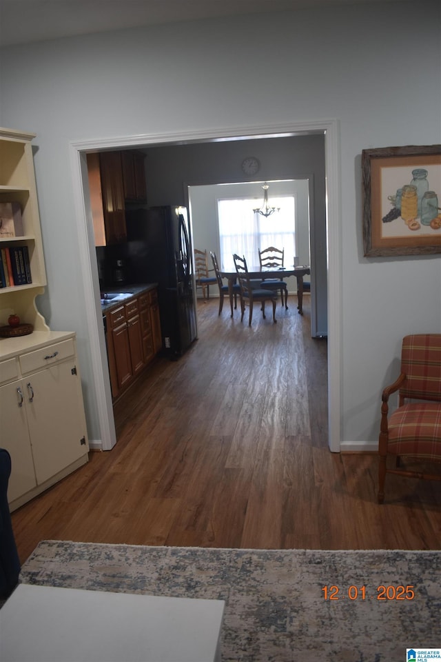 kitchen featuring dark hardwood / wood-style flooring and black fridge