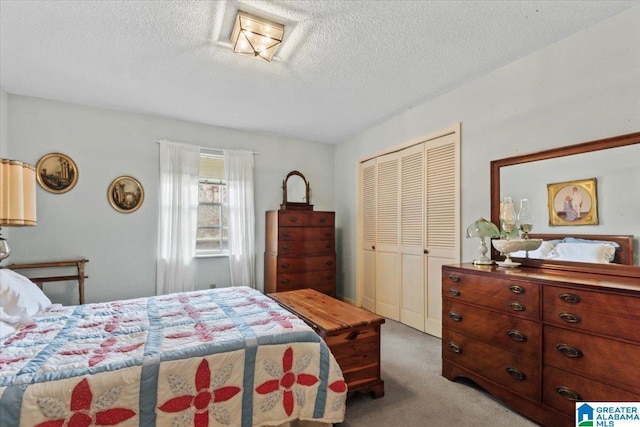 bedroom with a closet, light colored carpet, and a textured ceiling