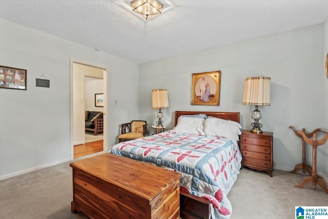 bedroom featuring light colored carpet and a textured ceiling