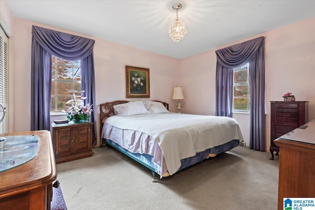 carpeted bedroom with a notable chandelier