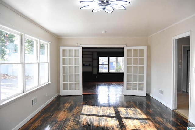 spare room with plenty of natural light, crown molding, dark wood-type flooring, and french doors