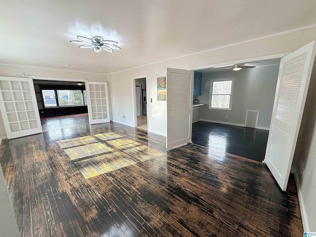 unfurnished living room featuring dark hardwood / wood-style flooring, ceiling fan, french doors, and crown molding